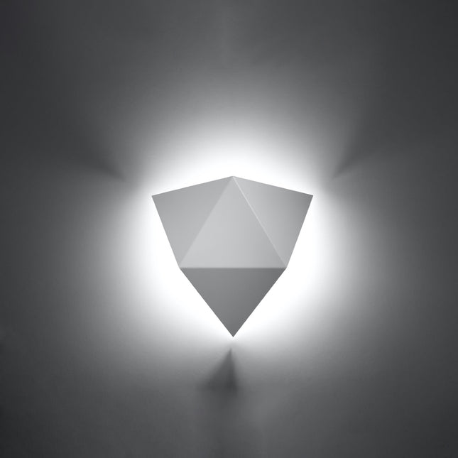 Applique murale géométrique triangle blanche allumée sur un mur clair