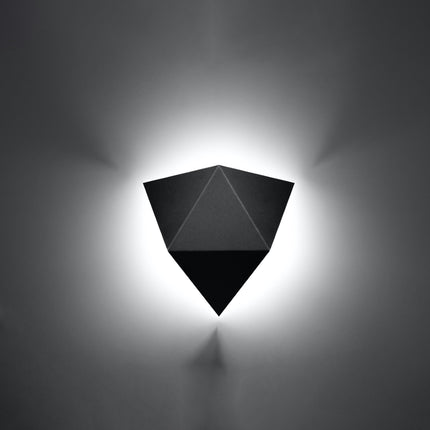 Applique murale géométrique triangle noire allumée sur un mur clair