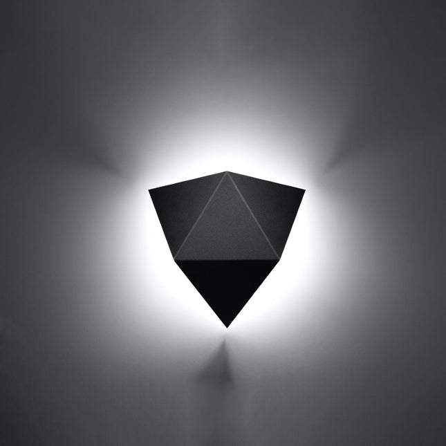 Applique murale géométrique triangle noire allumée sur un mur clair