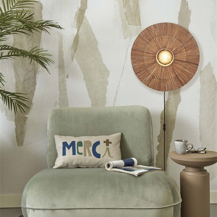 Lit Iguazu natural woven jute wall light above a green armchair in a bohemian living room
