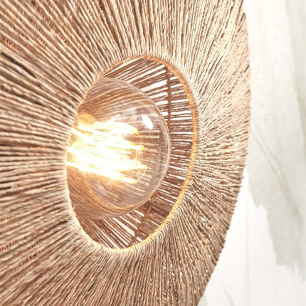 Detail of the lit E27 bulb at the center of the Iguazu woven jute wall light