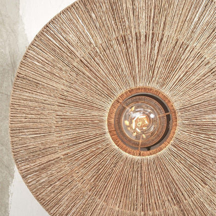 Close-up of the handcrafted natural jute weave of the Iguazu wall light around the bulb