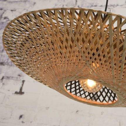 Abat-jour en bambou tressé naturel laissant filtrer la lumière chaude d'une ampoule