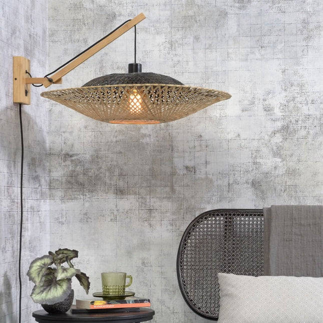 Lit Kalimantan woven bamboo wall light near a caned headboard