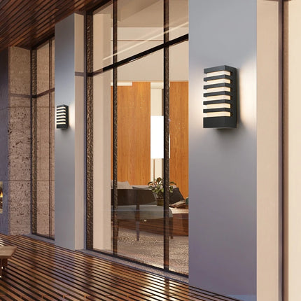 Applique murale LED anthracite installée sur un mur clair le long d'une baie vitrée