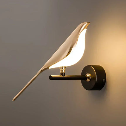 Applique murale LED dorée oiseaux au-dessus d'une table de chevet en chambre