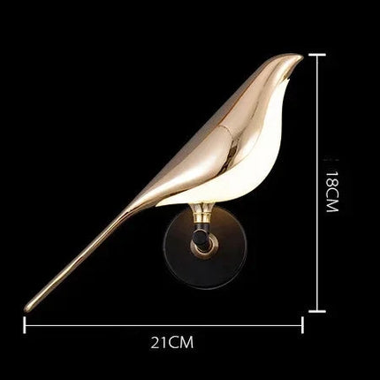 Applique murale LED dorée modèle à un oiseau sur un mur clair