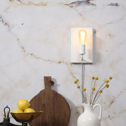Applique murale Madrid en fer blanc avec ampoule filament allumée dans une cuisine au mur en marbre clair