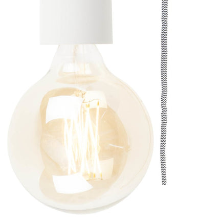 Gros plan sur l'ampoule globe filament et le câble textile chevron de l'applique murale Madrid en fer blanc
