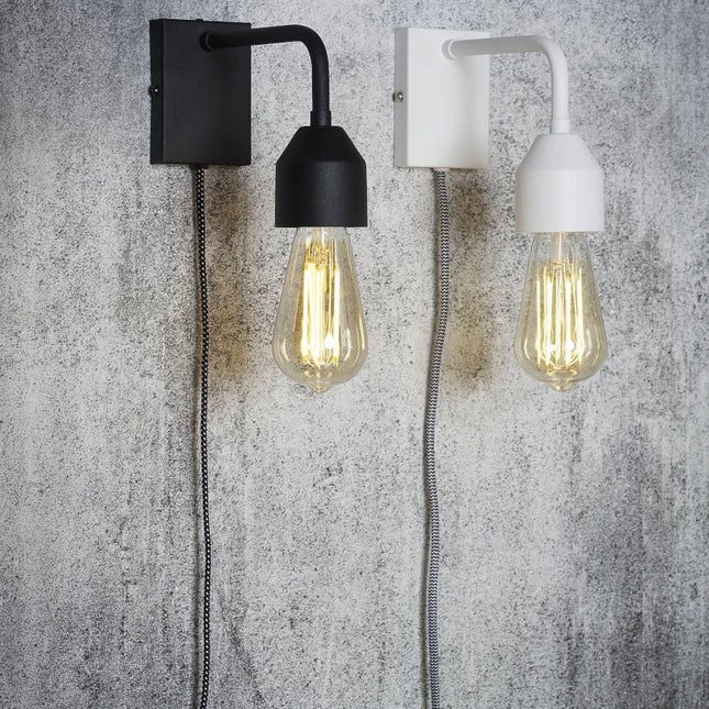 Pair of Madrid iron wall lights, black and white, textile cable and visible socket on a concrete wall