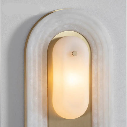 Détail du diffuseur ovale en verre dépoli et de la plaque en cuivre doré de l'applique en marbre