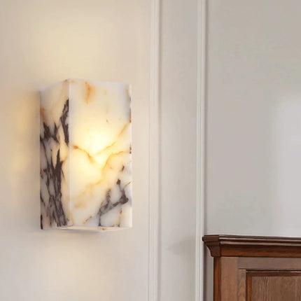 Applique murale en marbre naturel allumée près d'un meuble en bois, halo lumineux chaleureux