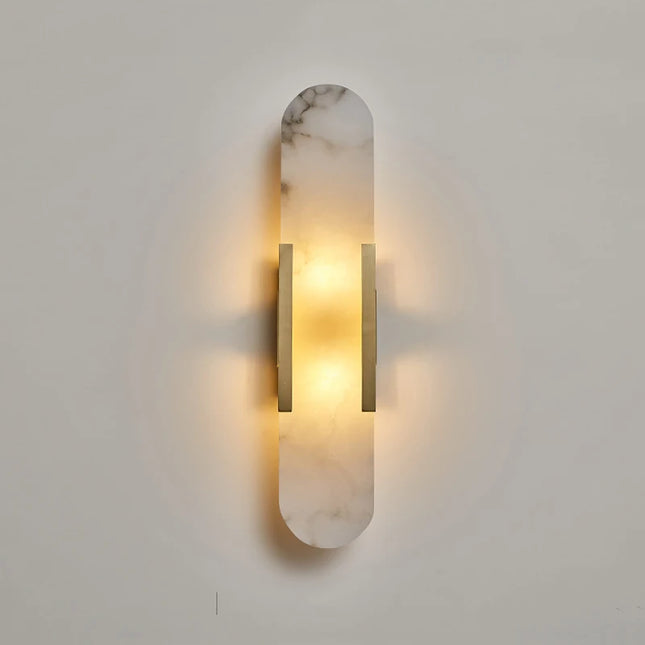 Applique en marbre naturel dorée allumée, halo de lumière chaude diffusé vers le haut et le bas sur le mur