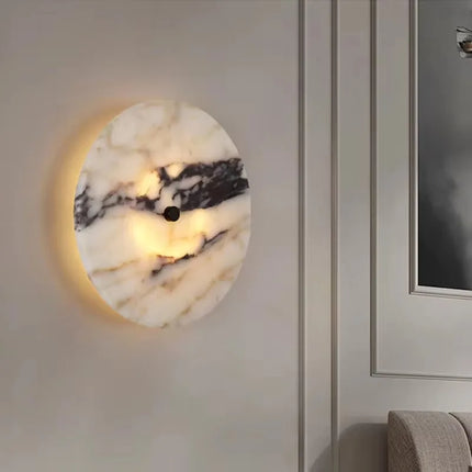 Applique murale en marbre naturel éclairée sur un mur clair près d'un miroir dans une entrée élégante