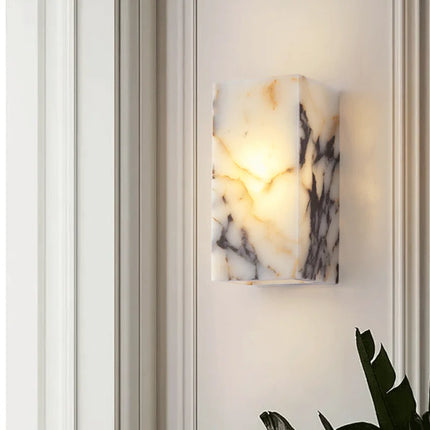 Applique en marbre naturel sur mur clair avec plante verte, éclairage tamisé haut et bas