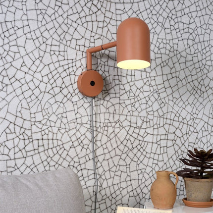 Applique murale terracotta Marseille installée au dessus d'un canapé, ambiance salon