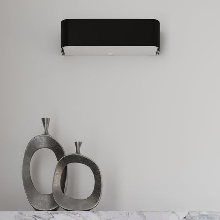 Applique murale noire assortie à la collection, posée au-dessus d'une console décorée
