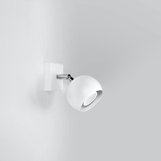 Applique murale oculaire spot orientable blanche posée dans un intérieur contemporain