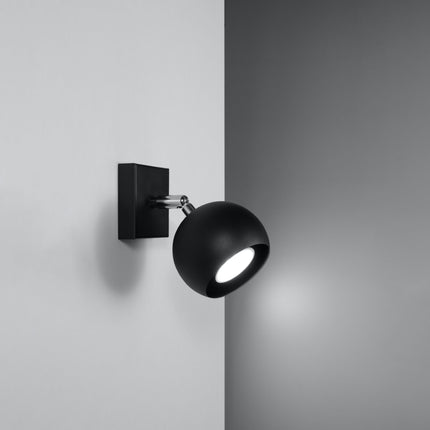 Applique murale oculaire spot orientable noire installée dans une pièce lumineuse