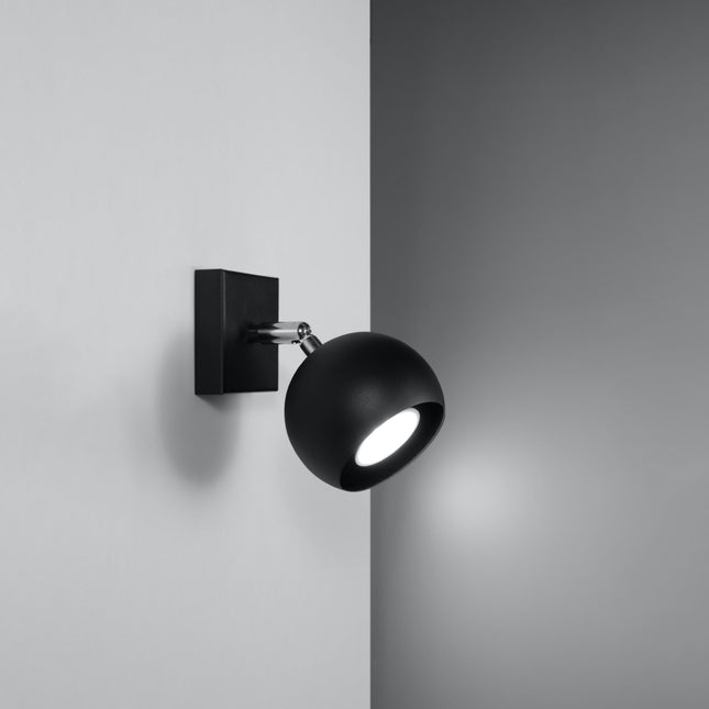 Applique murale oculaire spot orientable noire installée dans une pièce lumineuse