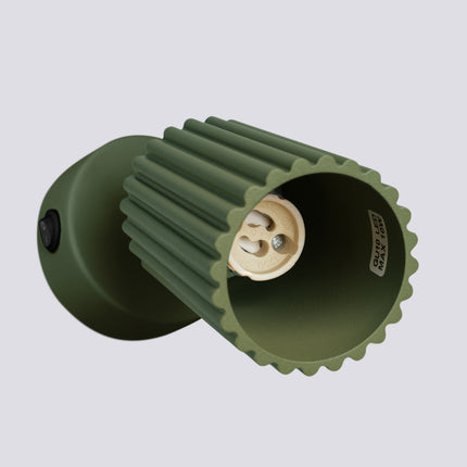 Applique murale orientable Oslo avec interrupteur vert olive, vue sur fond coloré