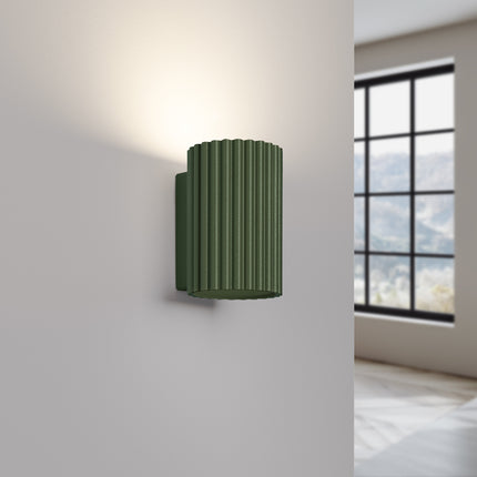 Applique murale Oslo 10 vert olive allumée dans une chambre en ambiance tamisée