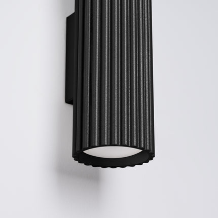 Gros plan sur l'ouverture inférieure cannelée de l'applique Oslo 30 noire, lumière GU10 diffusée