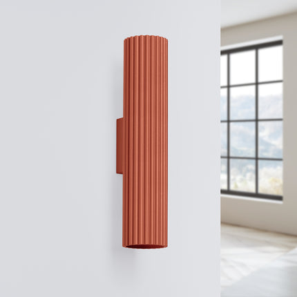 Applique murale Oslo 30 rouge ocre fixée au mur dans un intérieur clair et épuré, près d'une fenêtre