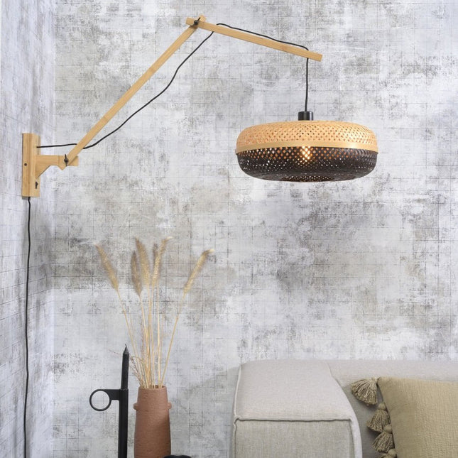 Palawan wall light with articulated bamboo arm, black and natural woven lampshade, in a living room
