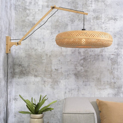 Applique murale Palawan bambou tressé installée dans un salon, bras en bois clair au-dessus d'un canapé