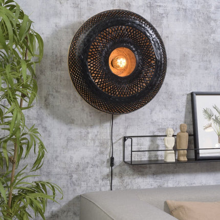 Applique murale Palawan en bambou tressé noir et naturel installée au-dessus d'un canapé dans un salon