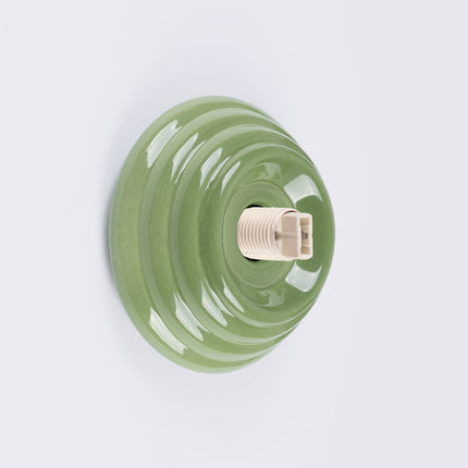 applique murale perle céramique vert olive ip44, vue sur fond coloré