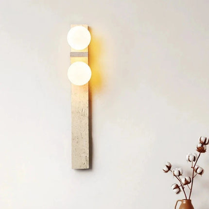Applique verticale en pierre diffusant une lumière douce dans une chambre