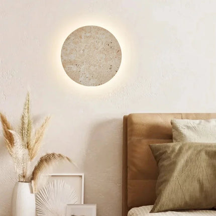 Applique murale ronde en travertin naturel diamètre 30 cm dans un intérieur nordique