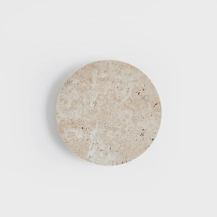 Applique murale ronde en travertin allumée diffusant une lumière douce