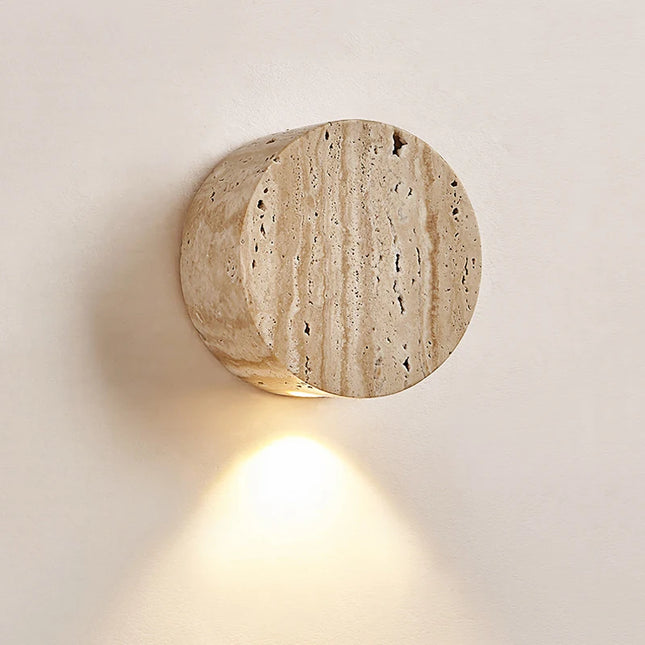 Applique murale ronde en travertin naturel dans une chambre apaisante