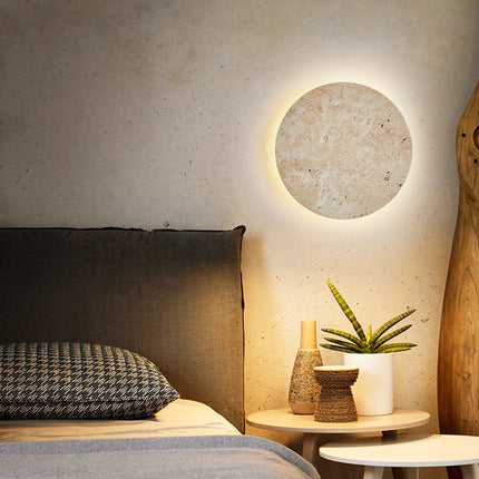 Applique murale ronde en travertin dans une chambre à l'ambiance apaisante