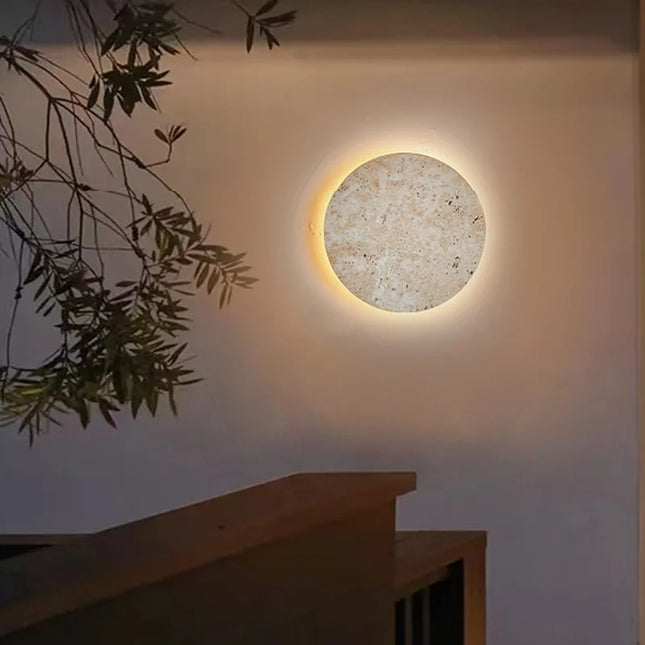 Applique murale ronde en travertin posée dans un salon chaleureux