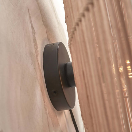 Black iron wall mounting bracket of the Tanami wall light, side view against the wall