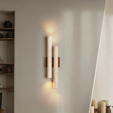Applique double en travertin et bois éclairant un mur clair le long d'une montée d'escalier