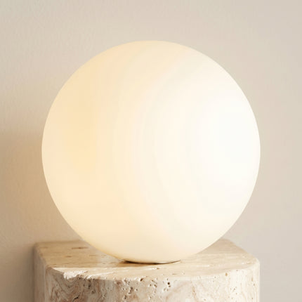 Gros plan globe opale applique murale travertin éclairage chaud diffus lumière douce 2700K