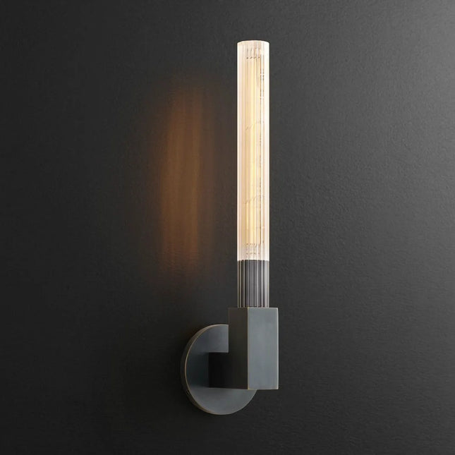 Applique murale tube en verre strié finition noire allumée sur un mur sombre