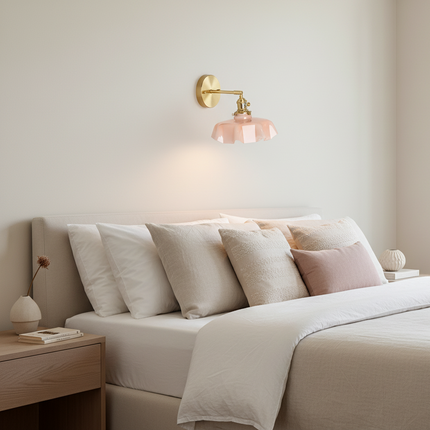 Applique murale en verre festonné rose et laiton doré au-dessus d'une tête de lit dans une chambre