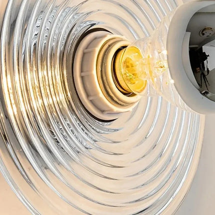 Applique murale en verre ondulé diffusant une lumière douce dans une chambre