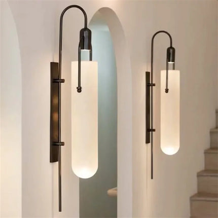 Appliques murales noires en verre opalin dans un couloir aux arches claires