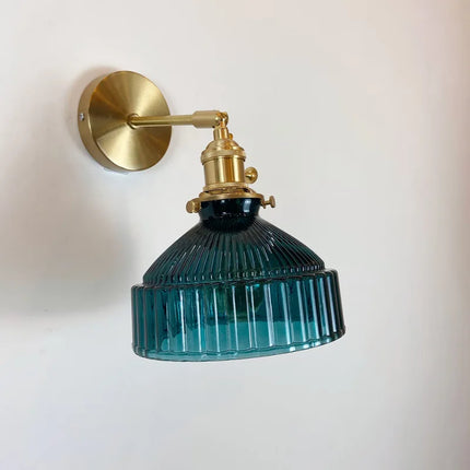 Détail de l'abat-jour cannelé en verre bleu profond de l'applique murale et sa douille laiton