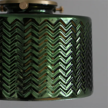 Détail du verre vert strié en relief à motif chevrons de l'abat-jour de l'applique murale