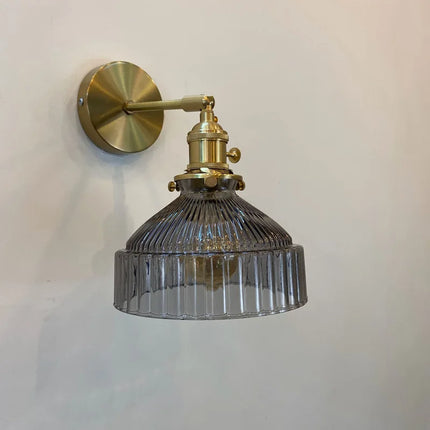 Vue de profil de l'applique murale en verre strié gris fumé sur bras orientable laiton