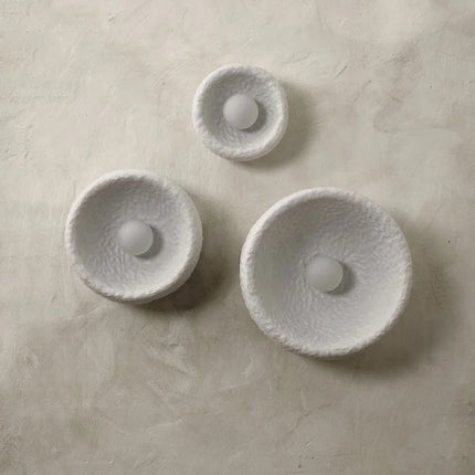 Trois appliques Wabi-Sabi en résine avec diffuseur en verre dépoli éteintes sur un mur crème