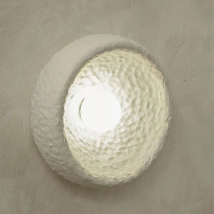 Appliques murales Wabi-Sabi installées sur un mur minéral dans une salle à manger japandi